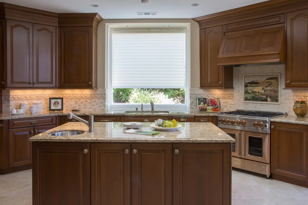 Cherry wood kitchen with granite island, custom range hood and window over the sink in Rancho Santa Fe