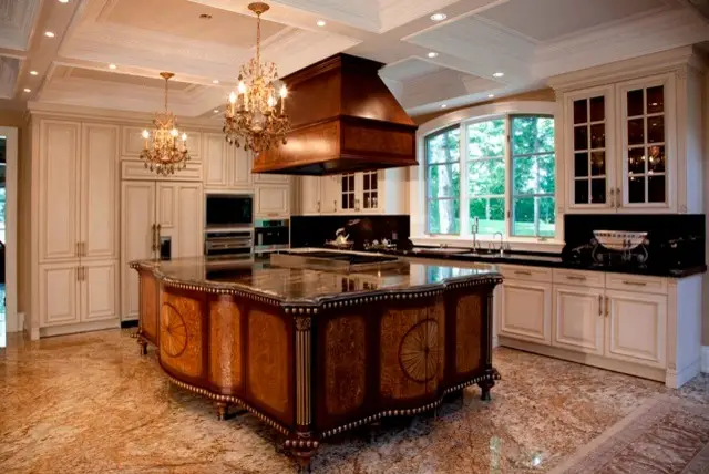 Luxurious kitchen with custom cabinets by Inplace Studio, featuring ornate wood island, marble flooring, and elegant chandeliers.