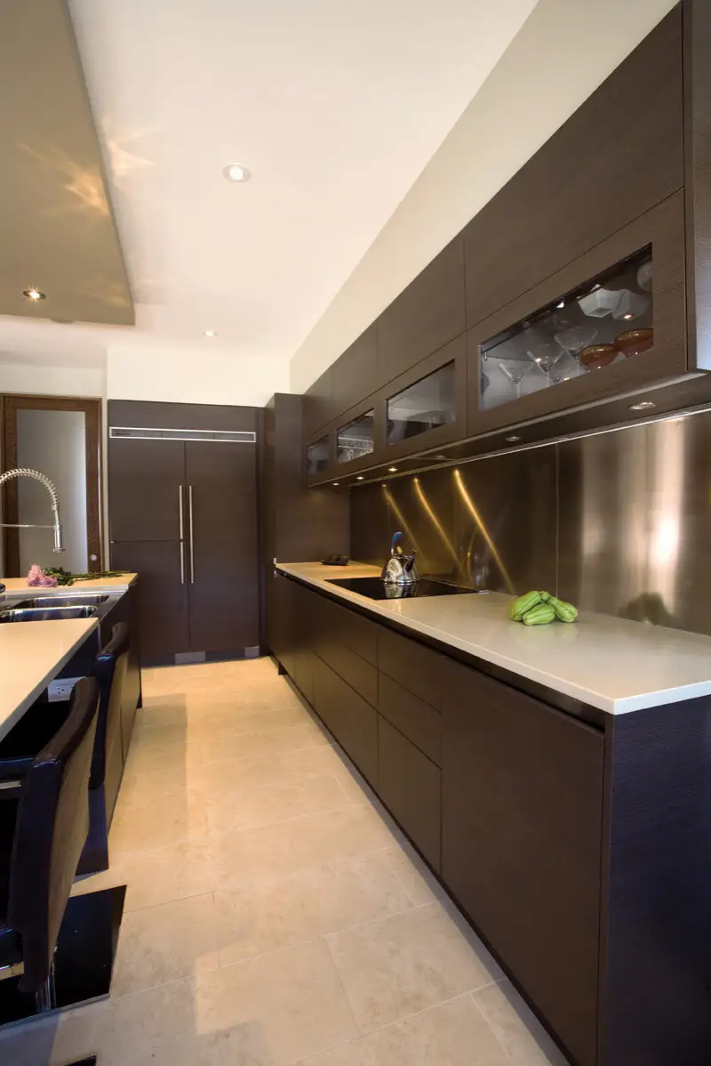 Modern kitchen interior with custom dark wood cabinets and sleek countertops, showcasing Inplace Studio's design capabilities for custom closets and cabinets.