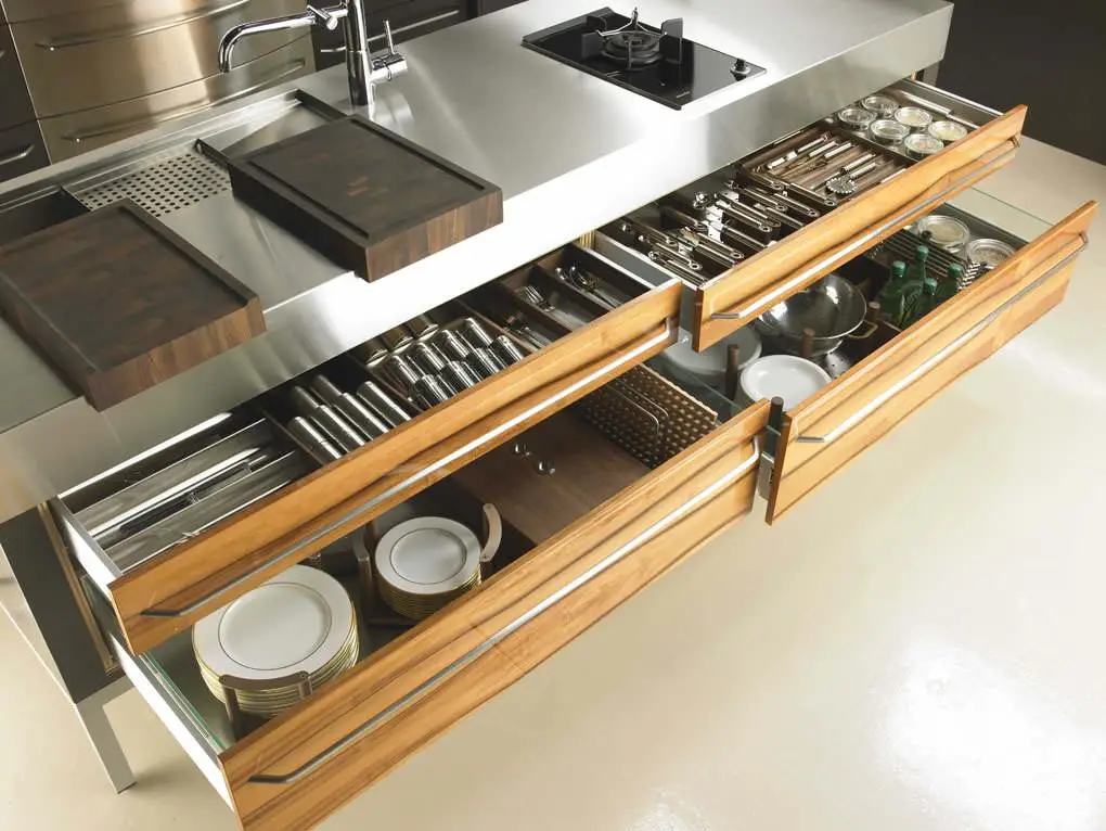 Modern kitchen island with open drawers showcasing organized utensils, cutlery, and dishes, custom designed by Inplace Studio for efficient storage.