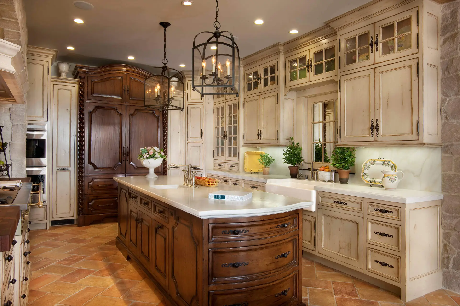 Luxury kitchen featuring custom cabinetry with classic design, elegant hanging lights, and a large central island with decorative paneling, showcasing a blend of modern and traditional elements. The kitchen includes sophisticated stainless steel appliances and a stylish farmhouse sink.