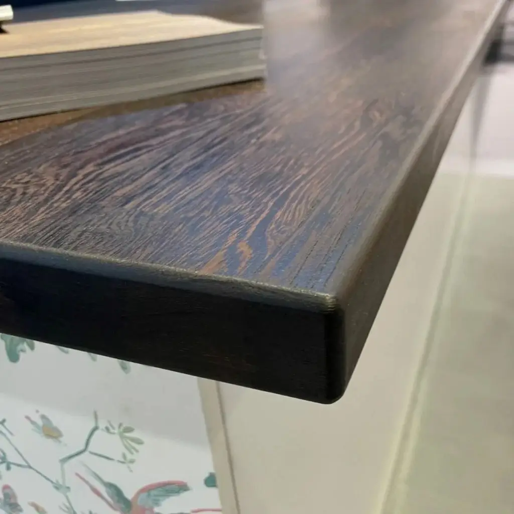 Close-up of a modern wooden kitchen countertop with a dark finish, showcasing the quality craftsmanship and design offered by Inplace Studio for custom cabinetry and kitchen solutions.
