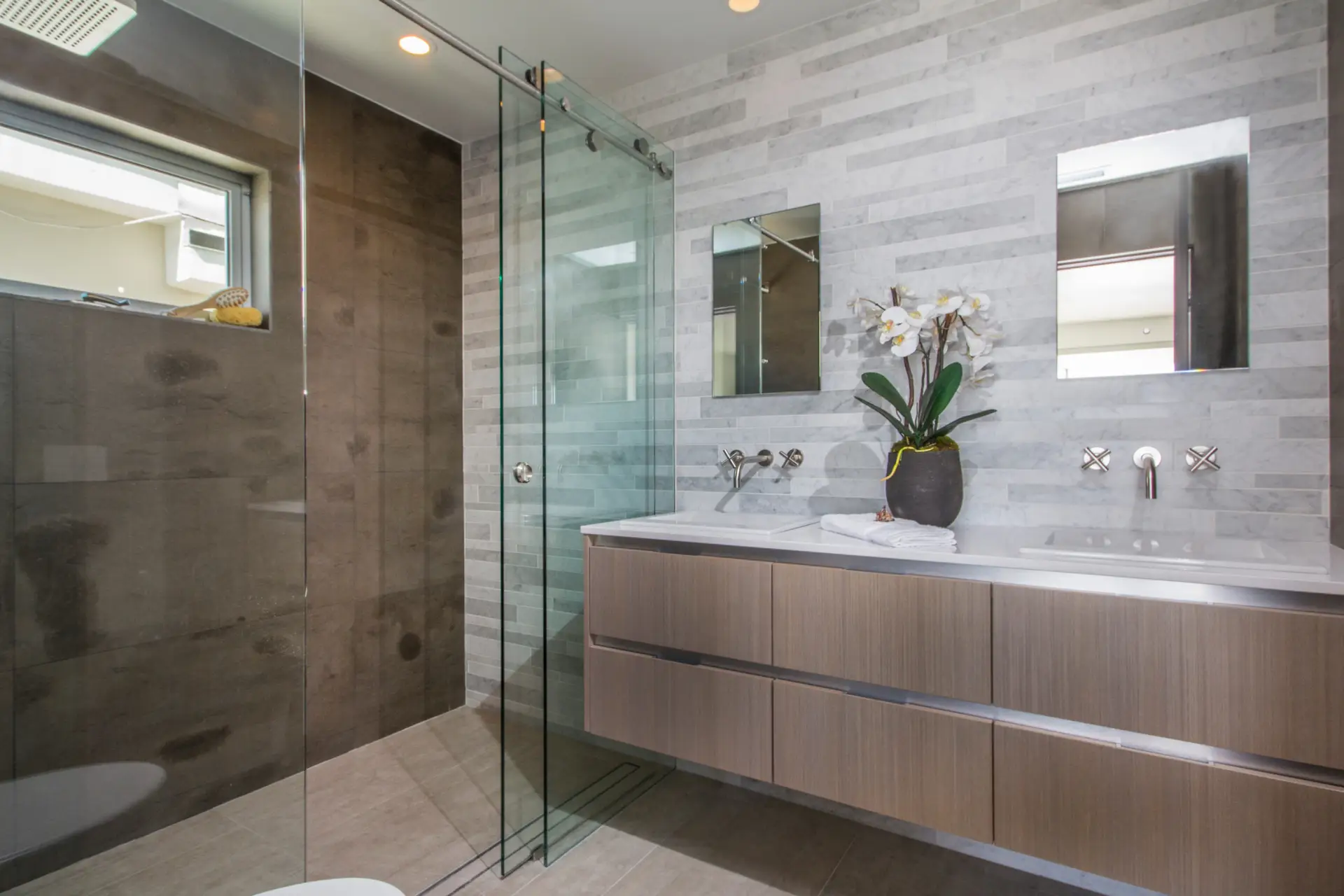 Modern bathroom with luxury custom cabinets and glass shower, featuring sleek design and elegant fixtures.