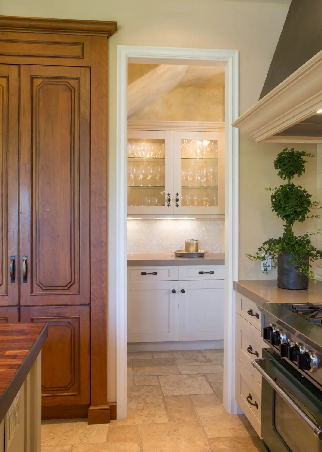 Image of a luxurious kitchen in Los Angeles showcasing custom cabinetry. The space features elegant wooden and white cabinets, glass-door storage, and a sophisticated countertop. This stylish kitchen design highlights upscale, custom storage solutions, emphasizing the elegance of high-quality cabinetry.