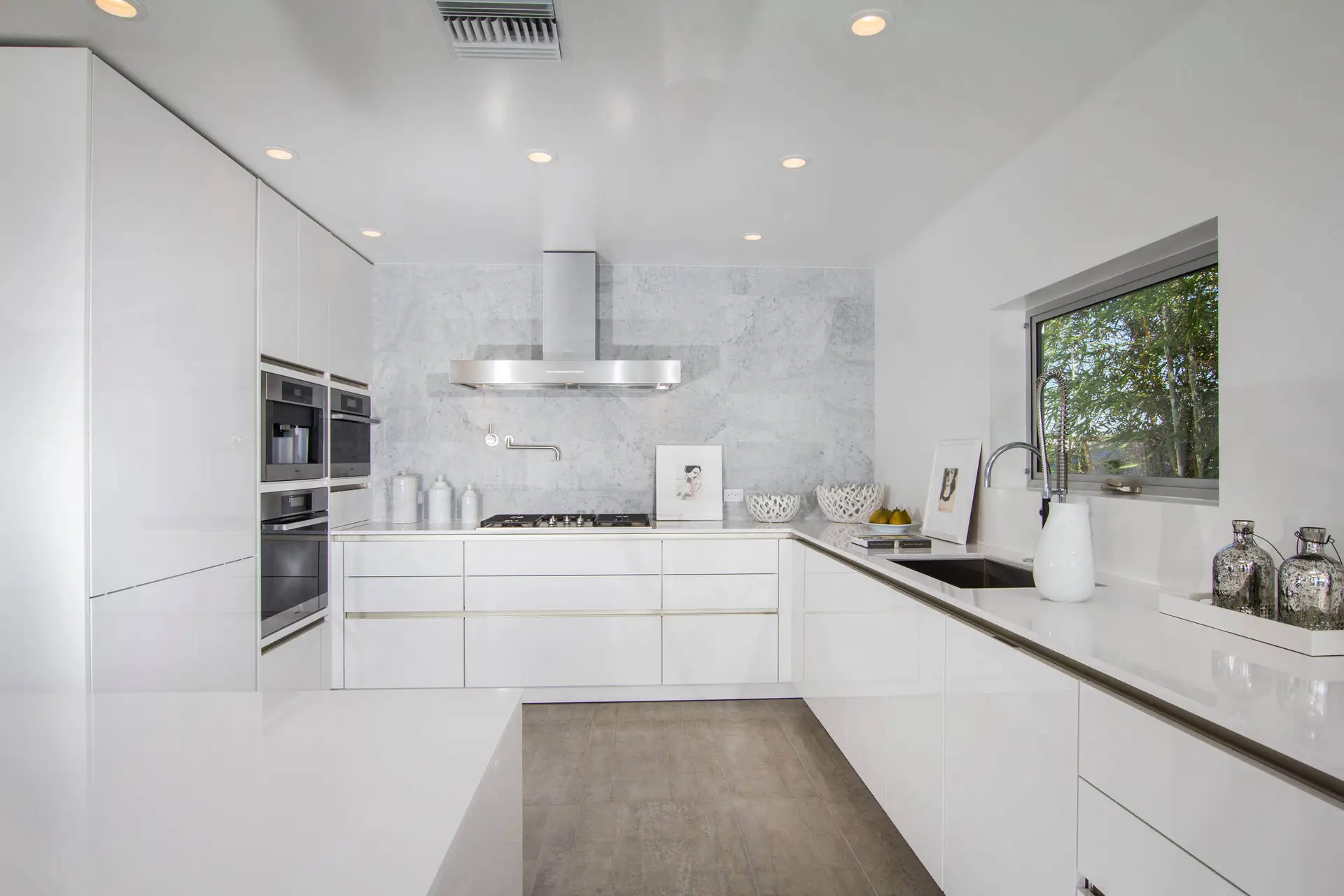 Modern kitchen with premium custom cabinets in Encinitas, featuring sleek white cabinetry, integrated appliances, and a minimalist design. Perfect for space transformation and contemporary home interiors.