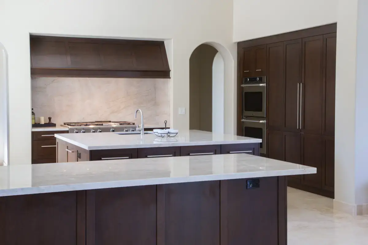 Modern kitchen with custom dark wood cabinetry, marble countertops
