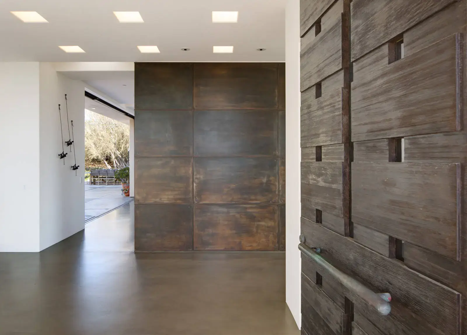 Modern European interior with luxury design elements, featuring sleek wood paneling and a stylish metal wall. Natural lighting enhances the sophisticated, minimalist aesthetic of the space, reflecting contemporary interior solutions.