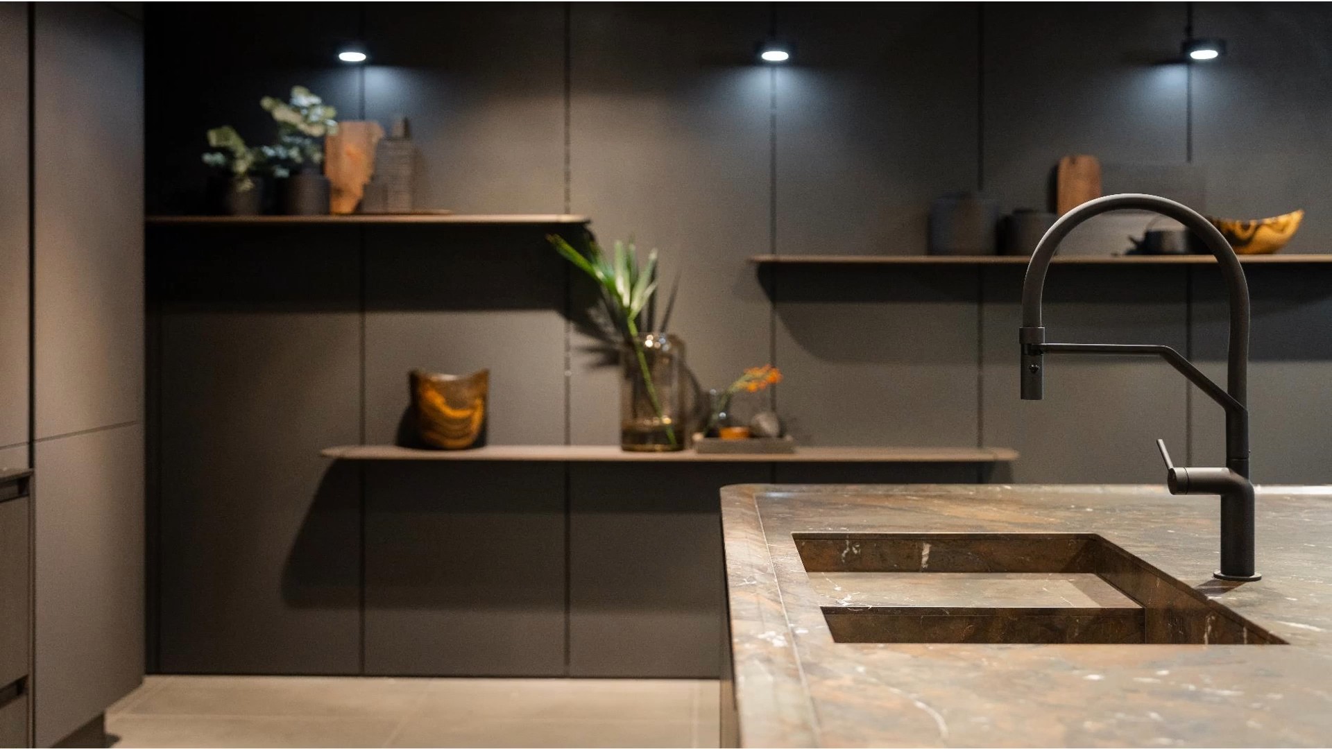 SieMatic SG6 dark kitchen with marble countertop and black fixtures