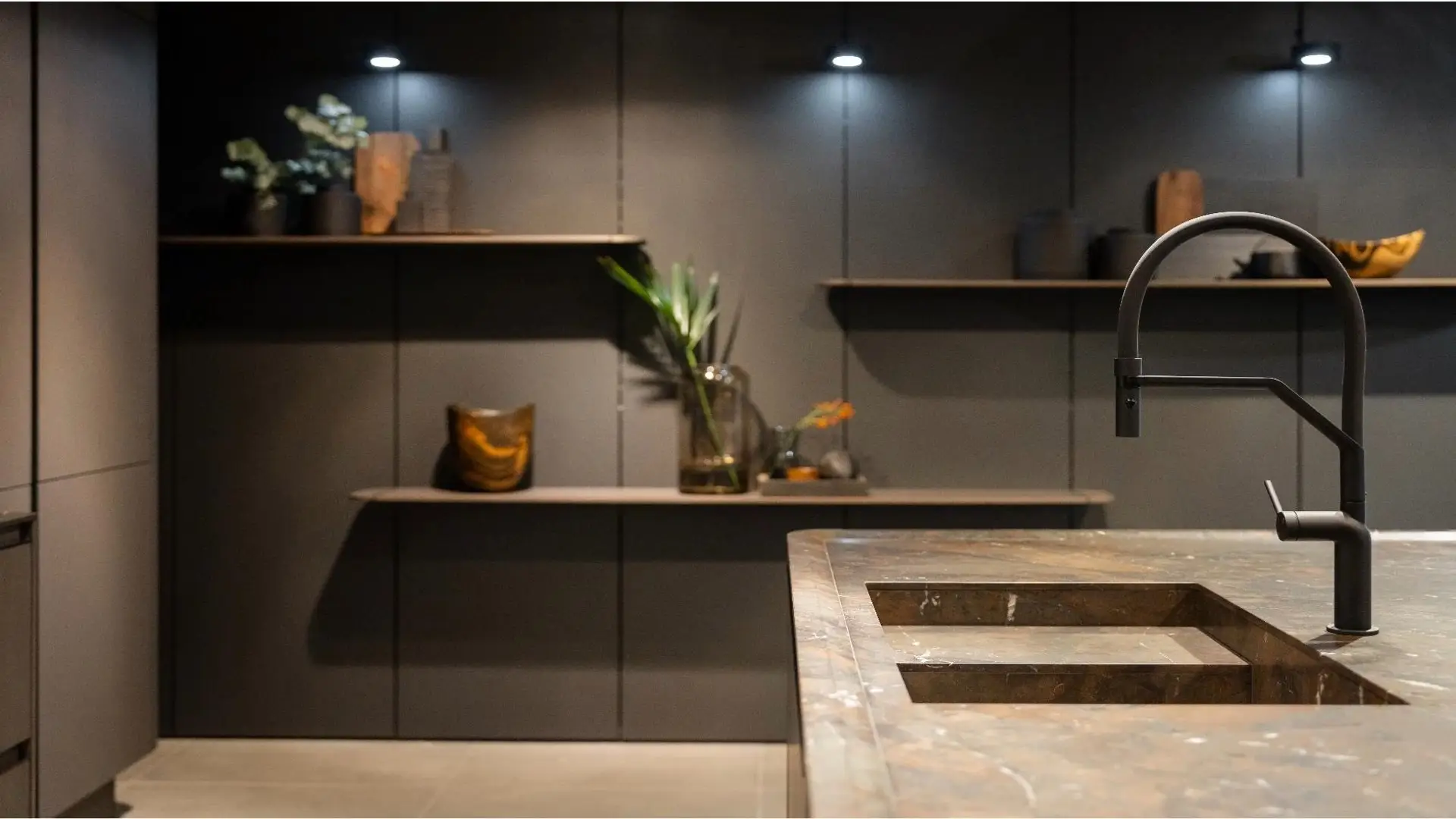 SieMatic SG6 dark kitchen with marble countertop and black fixtures