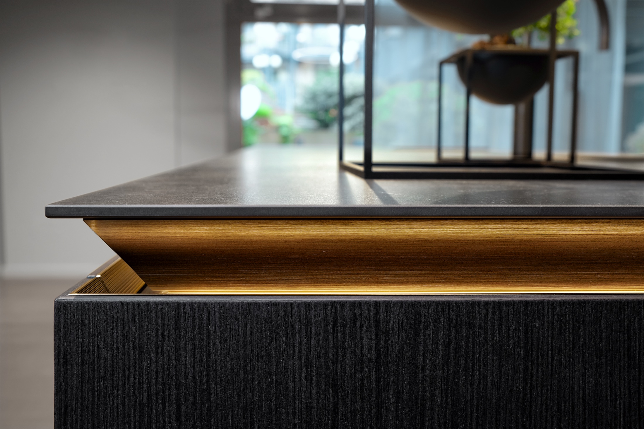 SieMatic SLX black oak island with illuminated gold grip channel &mdash; detail