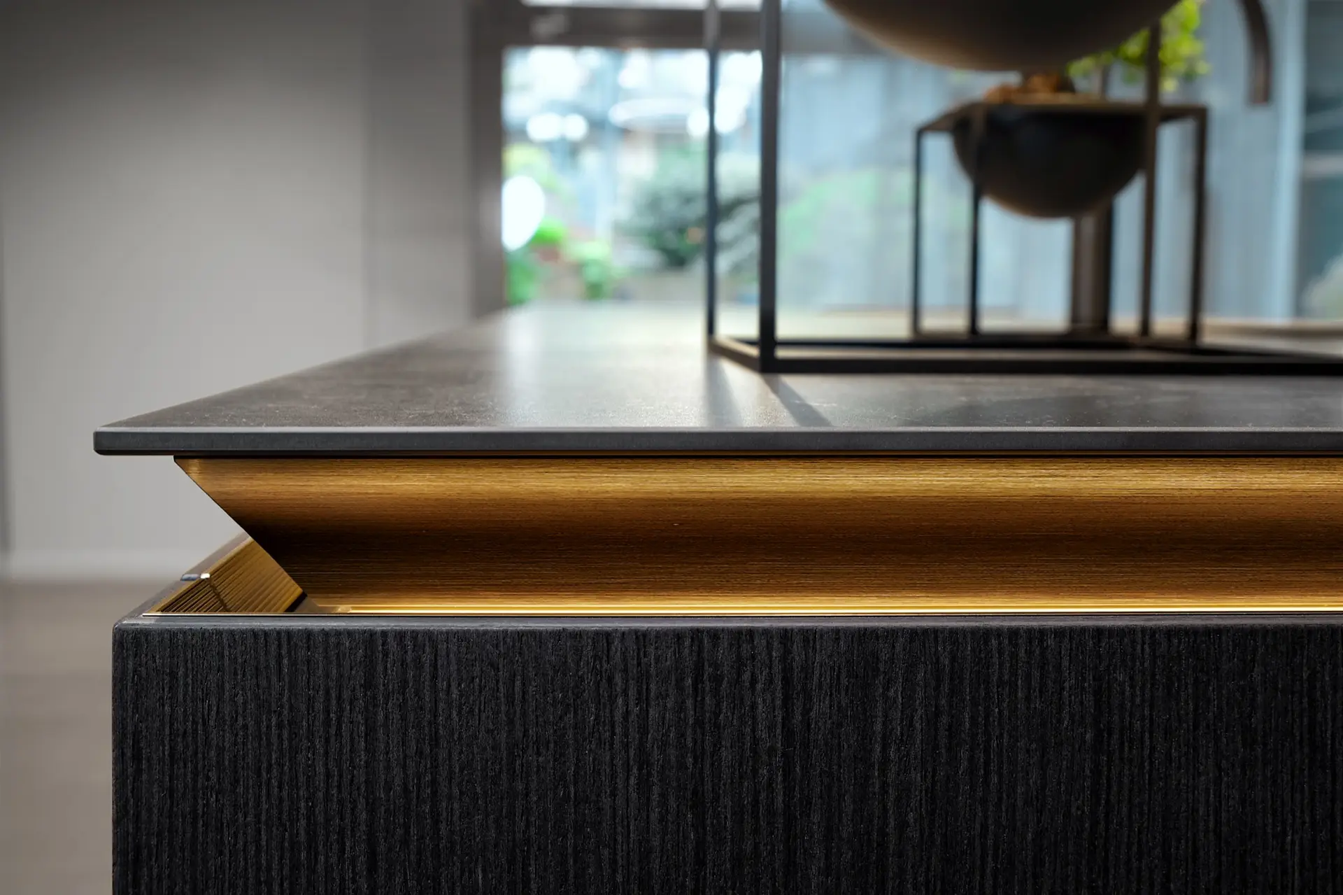SieMatic SLX black oak island with illuminated gold grip channel — detail