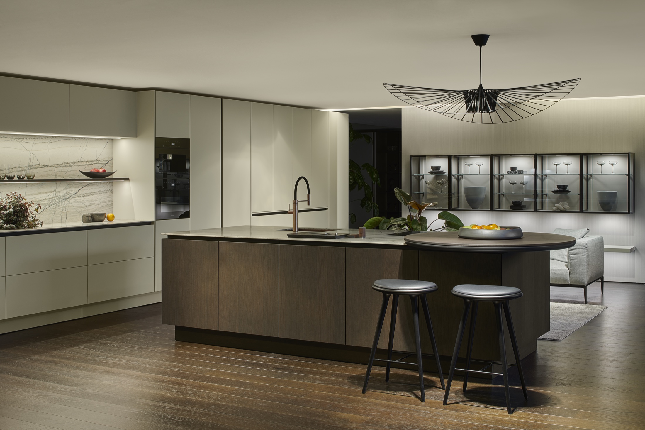 SieMatic SLX sage kitchen island with wall vitrines and pendant light