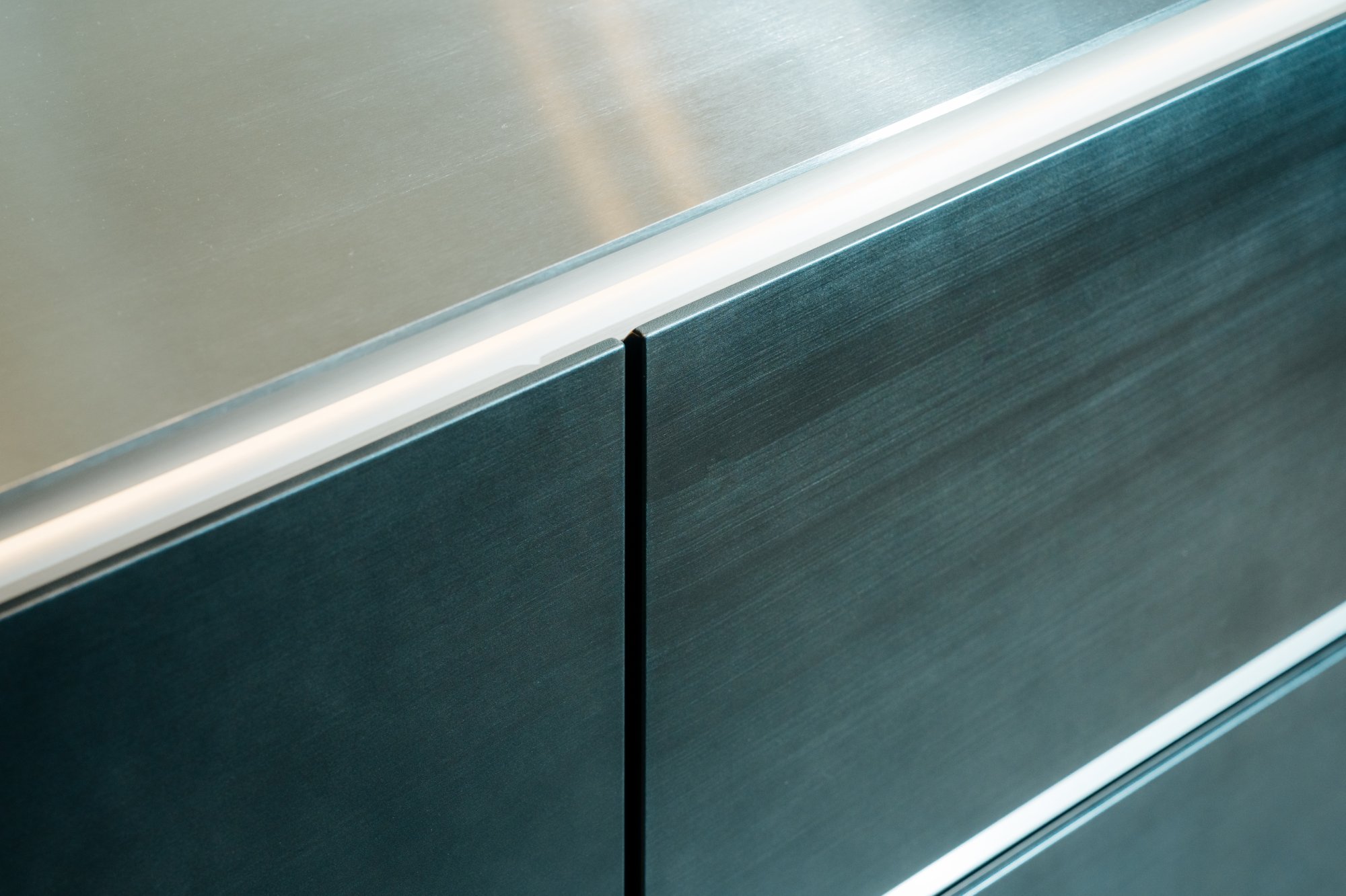 SieMatic SLX handleless steel island against Carrara marble niche wall