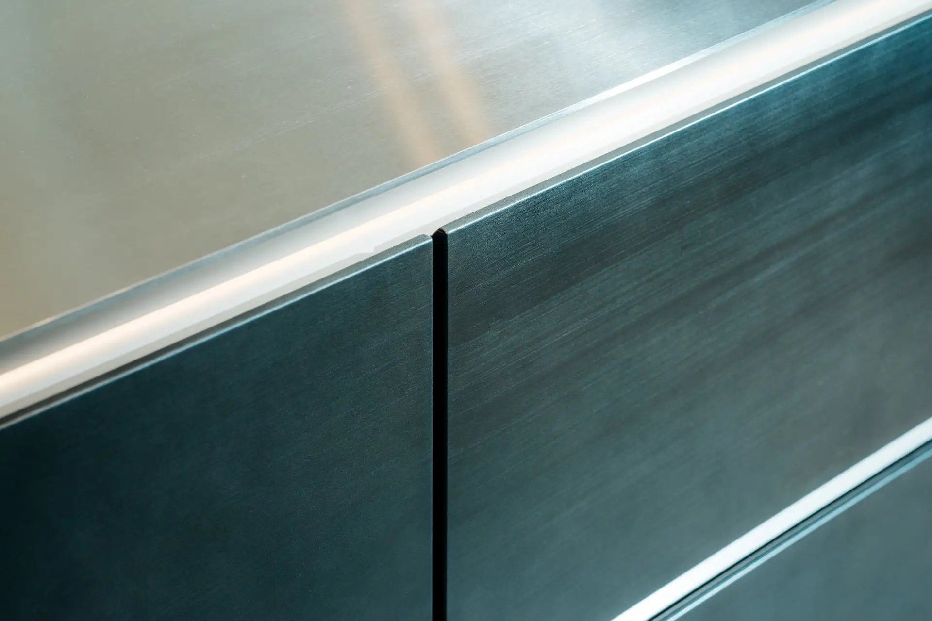 SieMatic SLX handleless steel island against Carrara marble niche wall