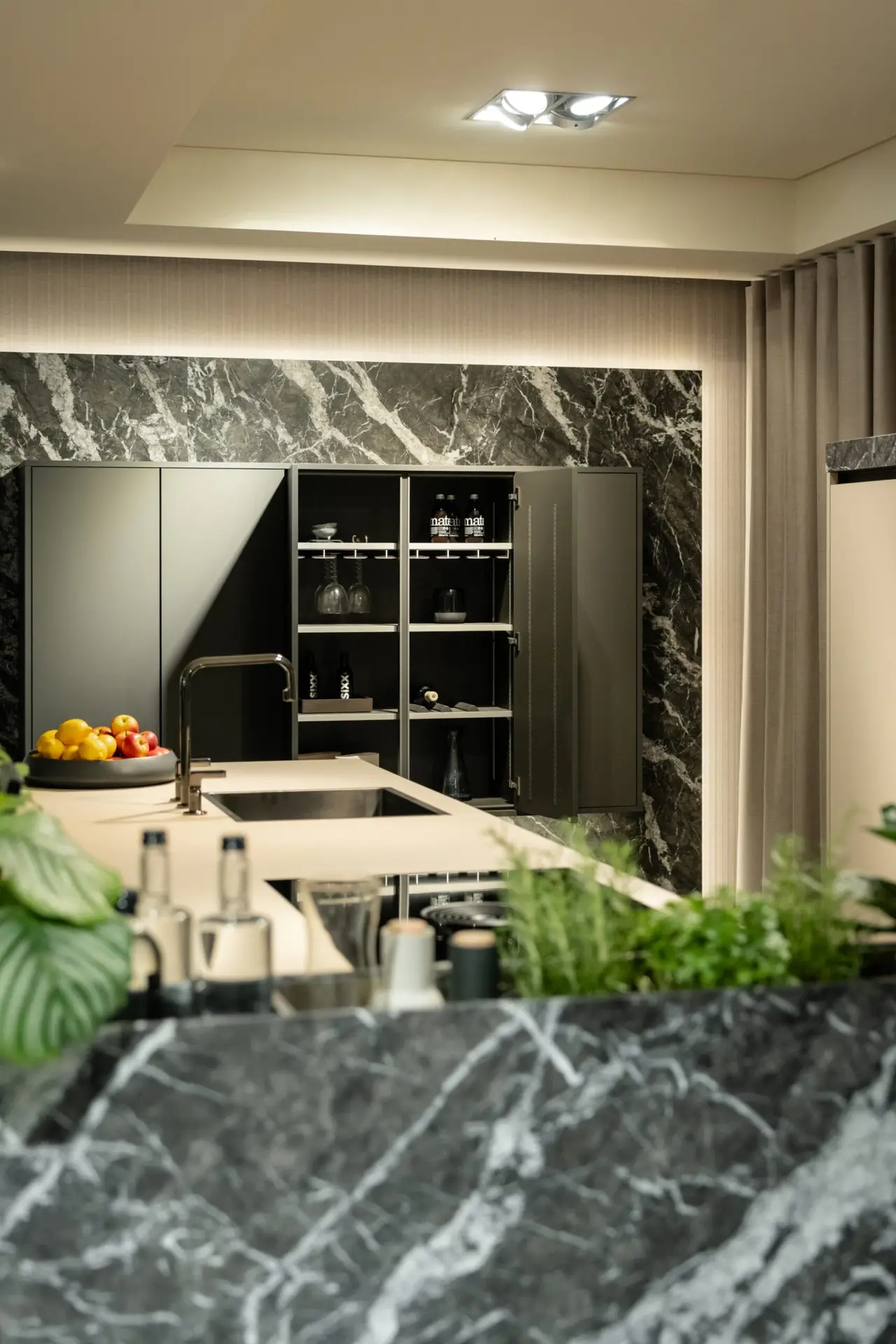 SieMatic wall cabinets opened against dark marble backsplash