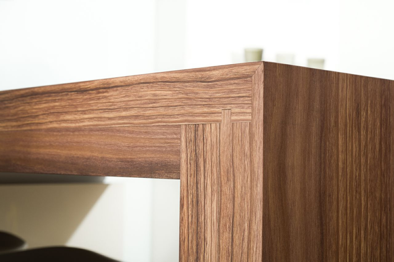 Close-up of luxury custom cabinetry with elegant wood grain finish, showcasing expert craftsmanship in closet design.