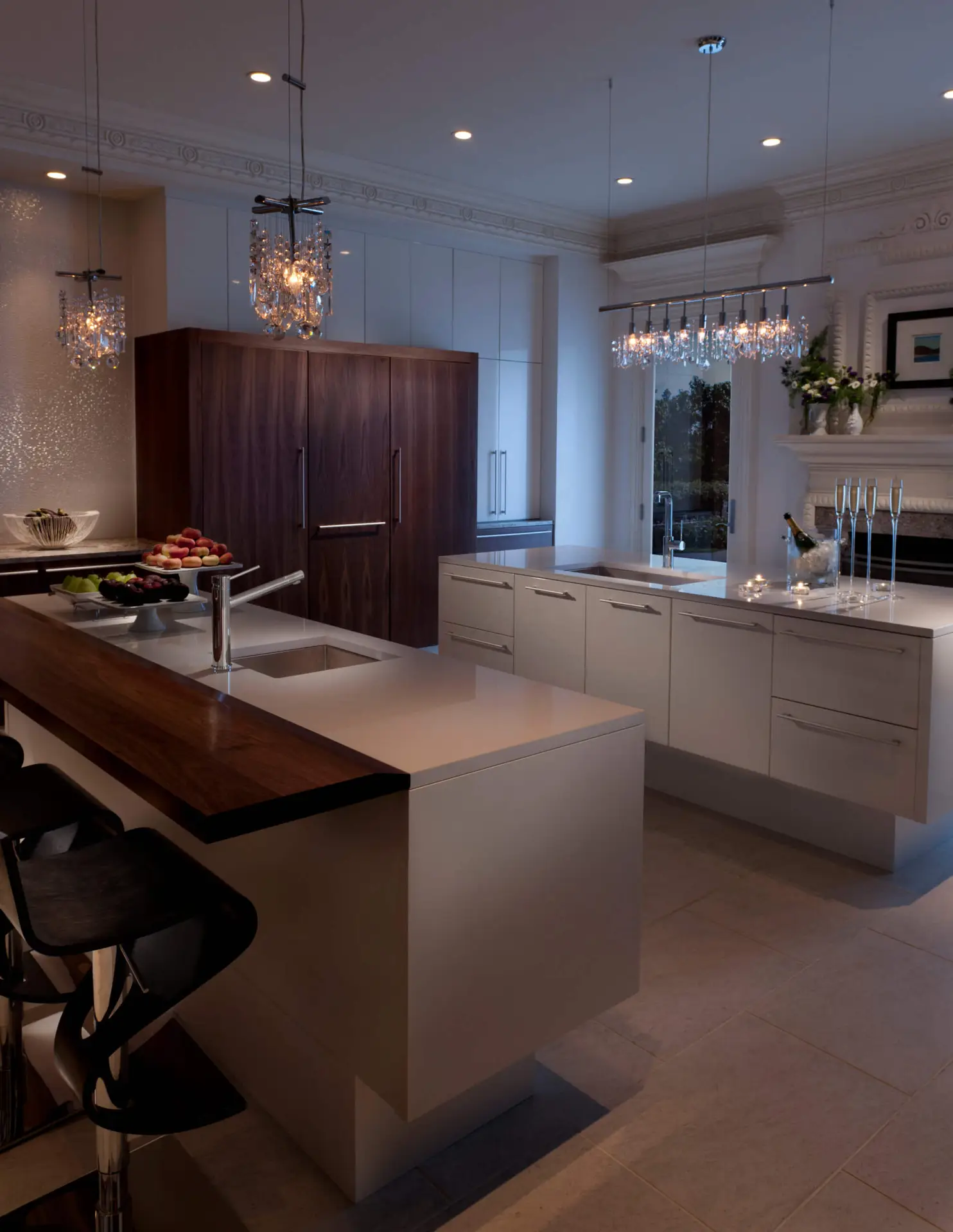 Luxurious kitchen design featuring modern transitional cabinetry, elegant crystal pendant lighting, and a chic combination of dark wood and light countertop surfaces, creating a sophisticated ambiance.