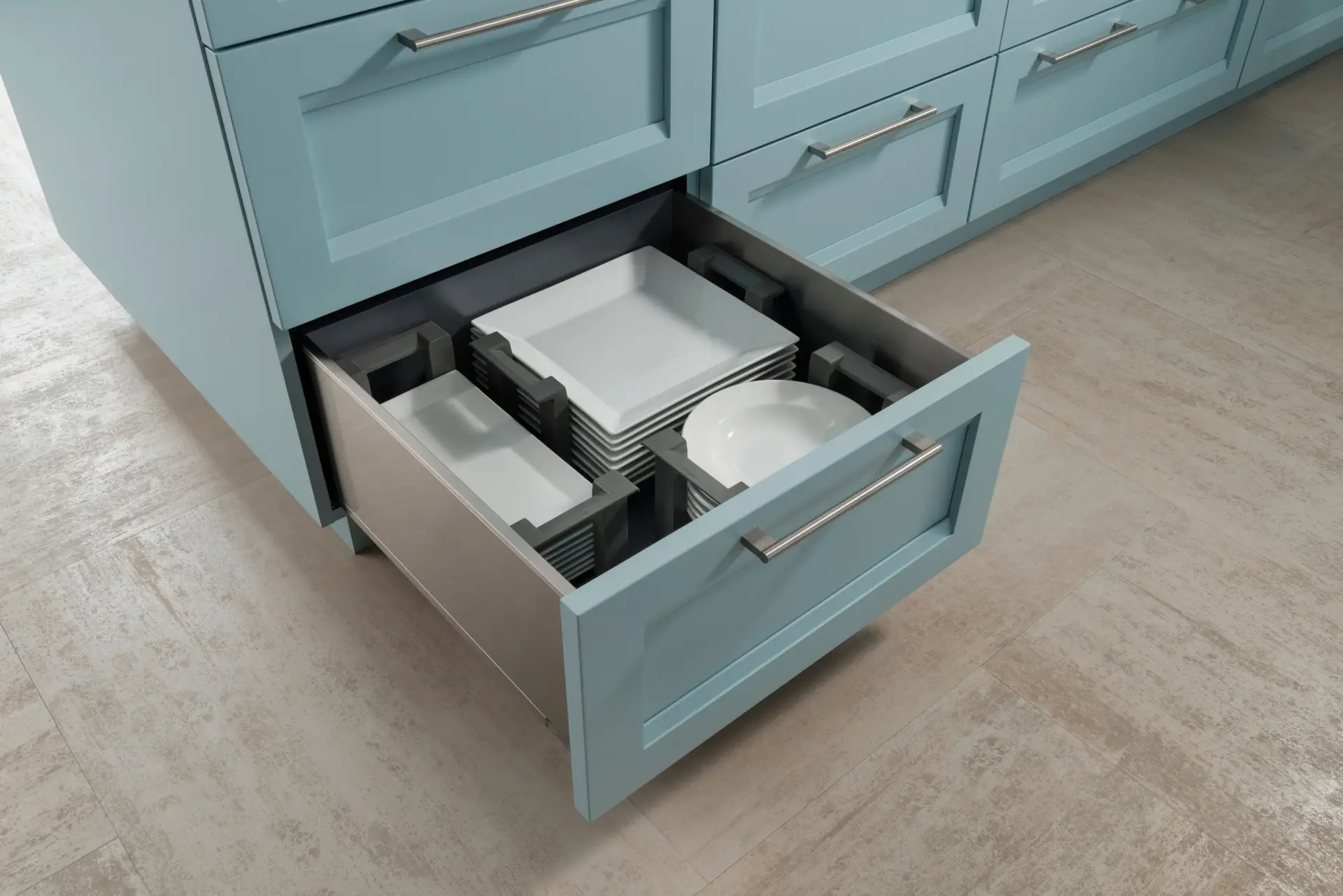 Elegant custom cabinetry in San Diego featuring light blue drawers with stainless steel handles, showcasing efficient storage with neatly stacked white dishes inside a spacious open drawer.