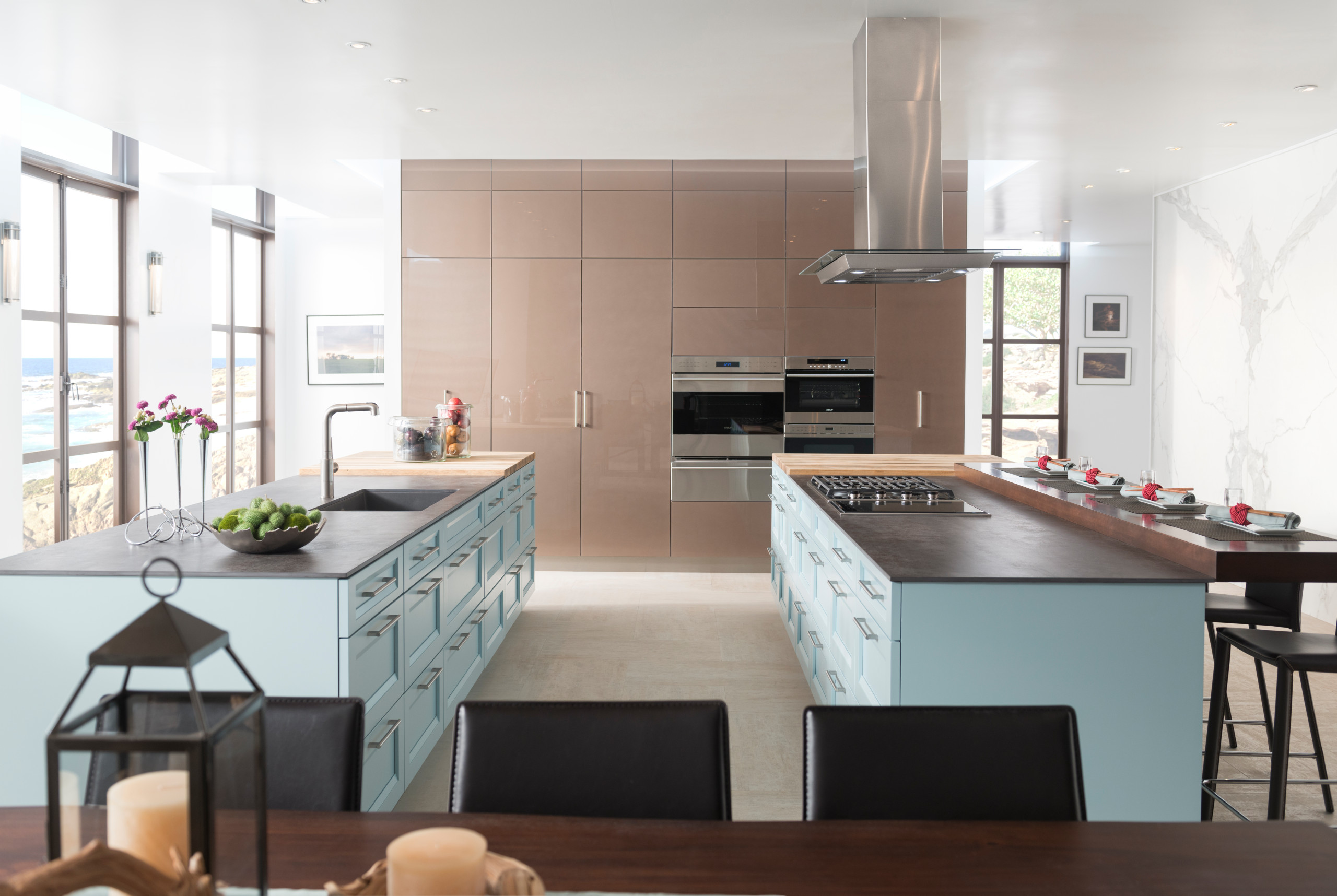Elegant modern kitchen with custom cabinetry in San Diego, featuring sleek light blue storage cabinets and a spacious kitchen island with bar seating, providing ample counter space and a contemporary design aesthetic.