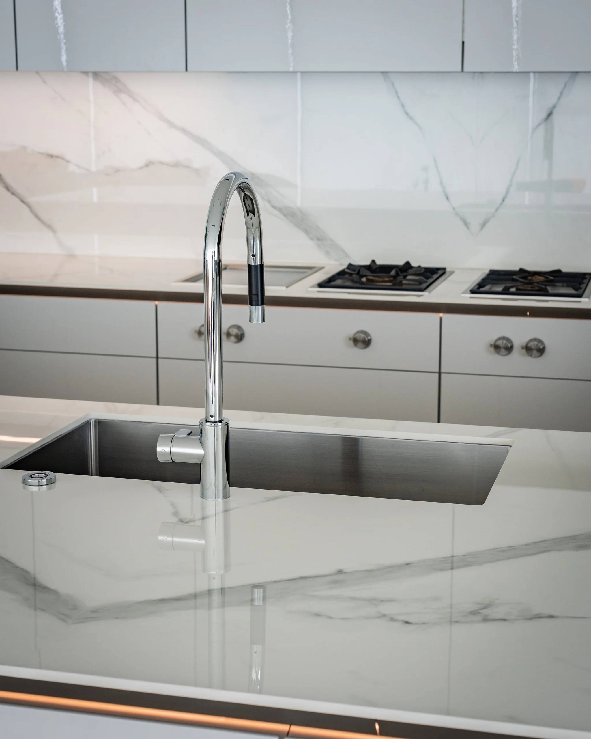 Undermount stainless sink and chrome pull-down faucet set in a marble-look countertop
