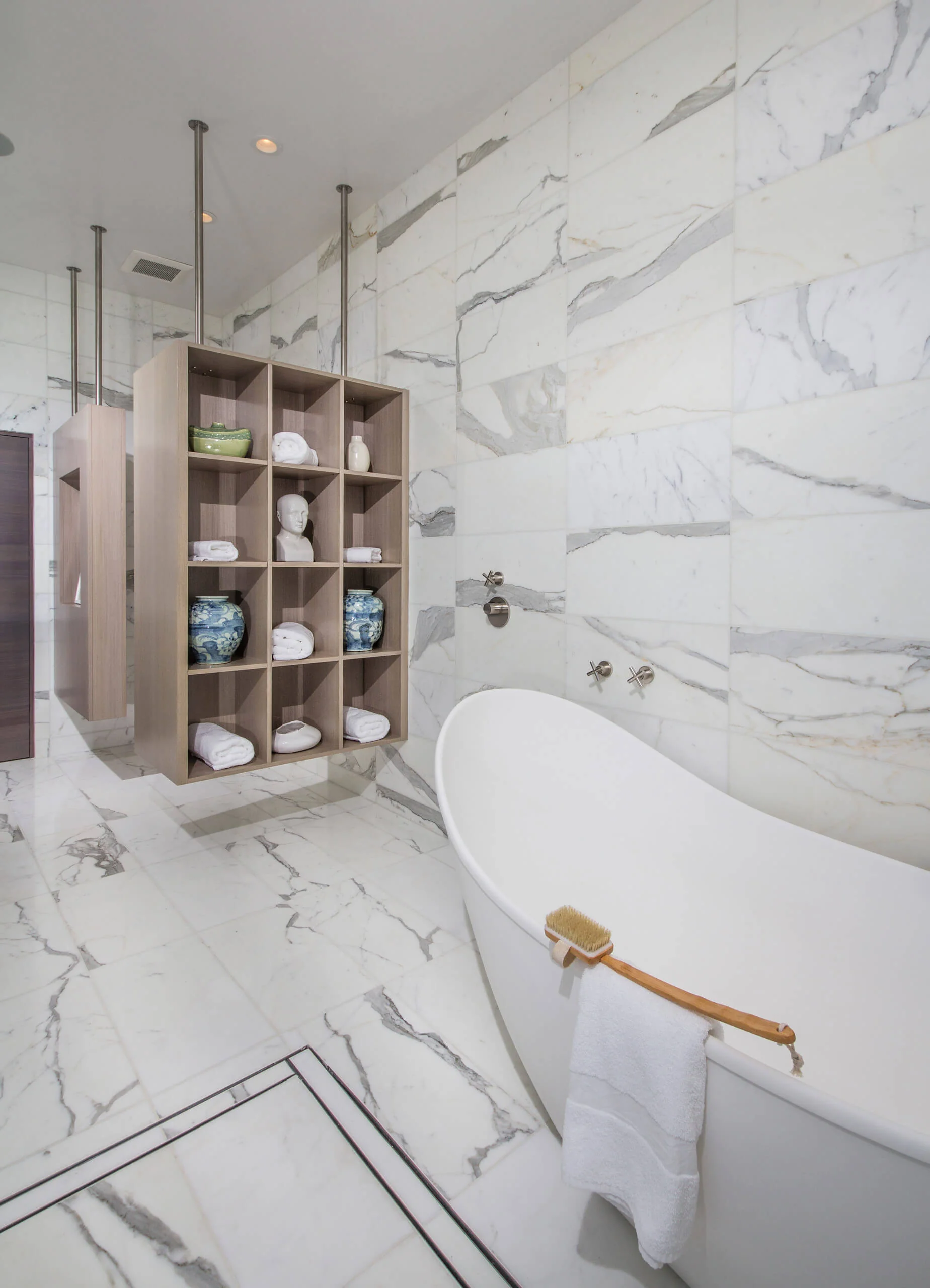 Luxurious bathroom with marble tiles, a freestanding white bathtub