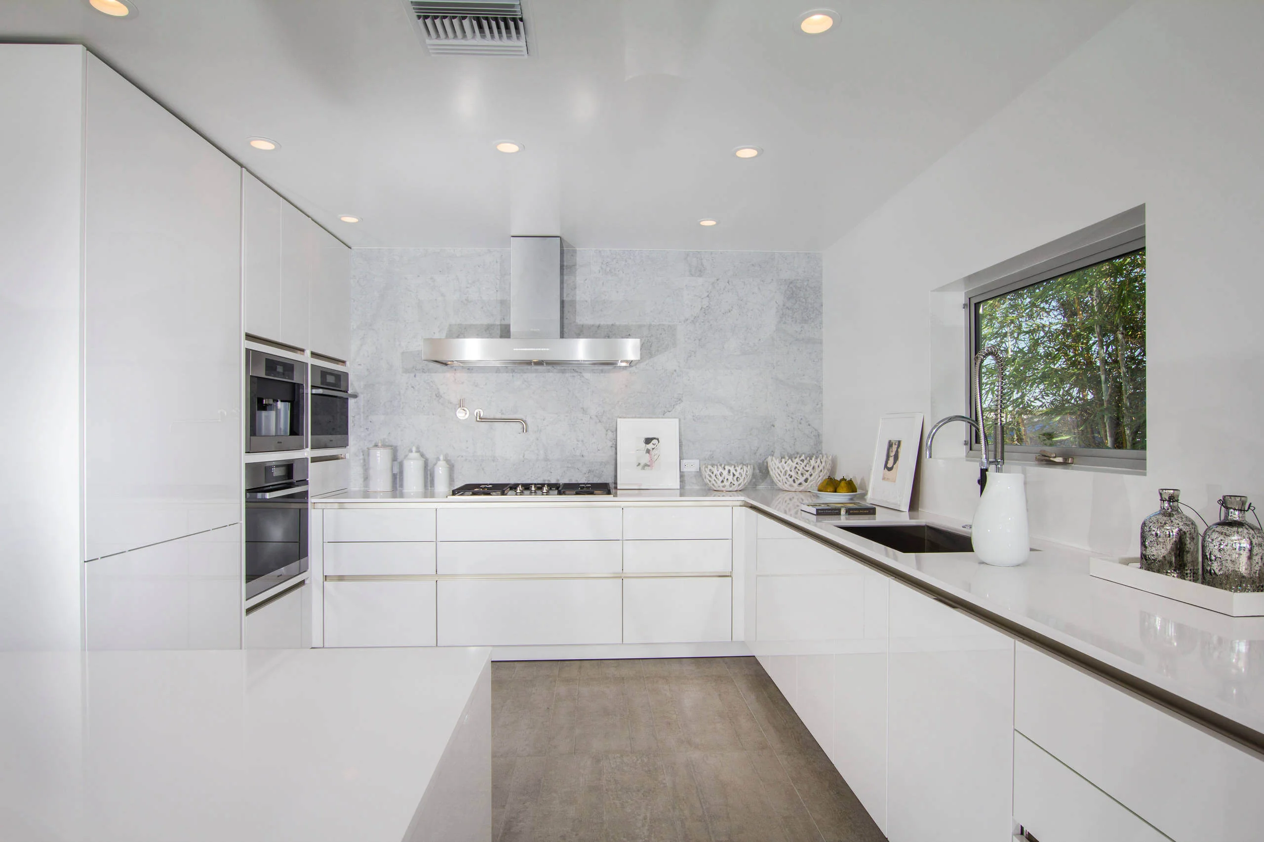 Modern kitchen with premium custom cabinets in Encinitas, featuring sleek white cabinetry, integrated appliances