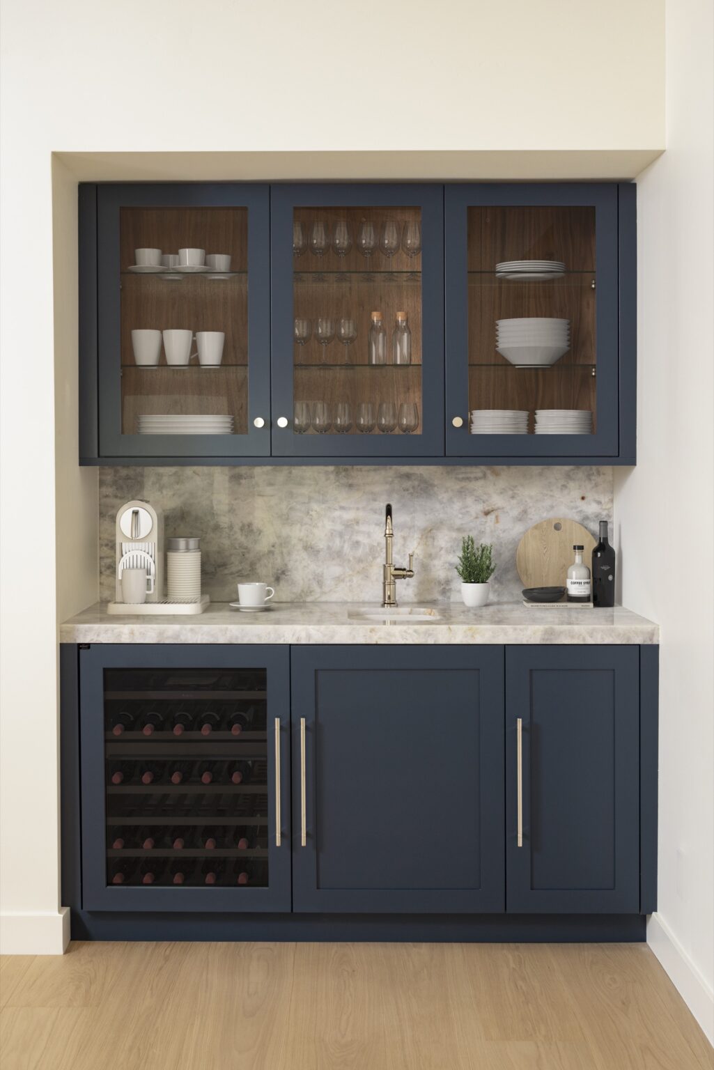 Wood-Mode wet bar in Deep Aegean blue with glass-front upper cabinets, walnut interiors