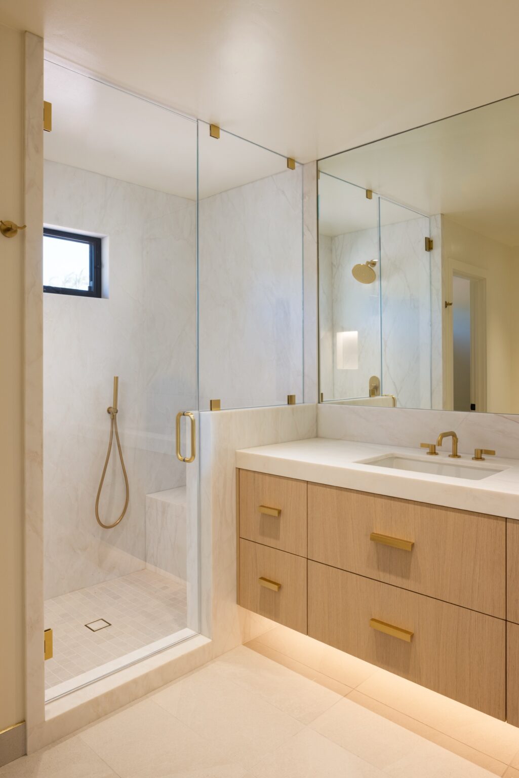 Primary bathroom with a floating white oak vanity, under-vanity lighting