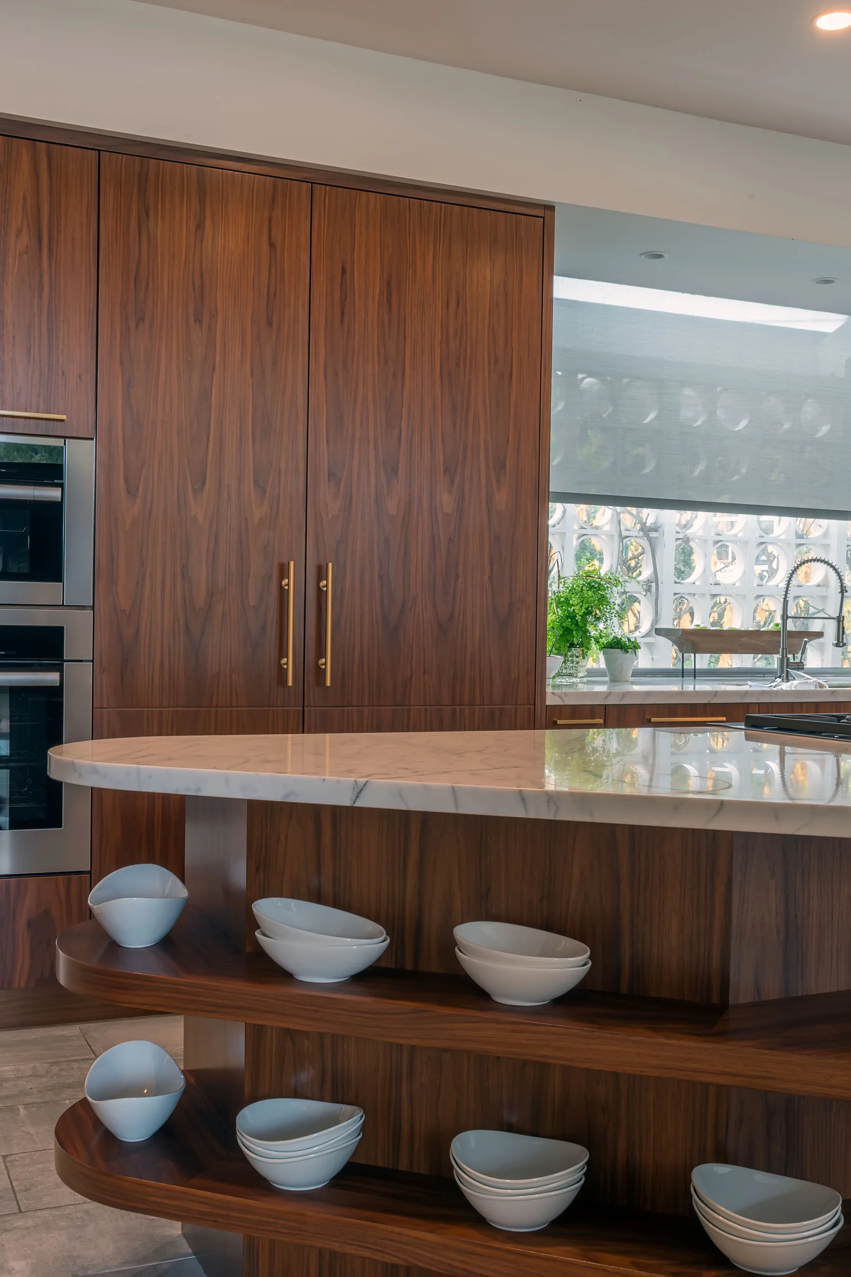 Contemporary kitchen with custom wooden cabinetry, featuring modern stainless steel appliances and a sleek marble