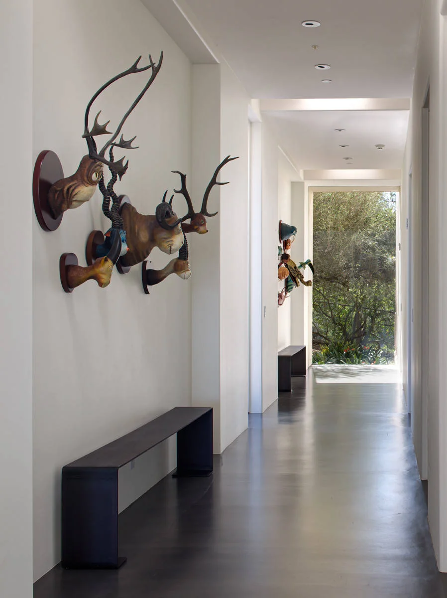 Rancho Santa Fe home hallway with sculptural wall art and a view to the garden