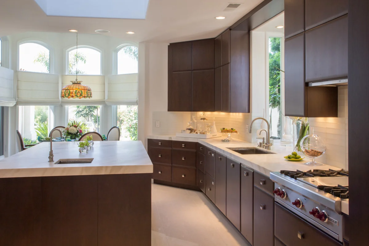 Luxury modern kitchen with custom dark wood cabinetry and white countertops