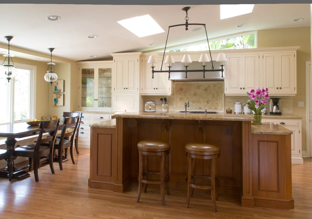 Luxury kitchen design featuring custom white cabinetry, granite countertops, and elegant light fixtures